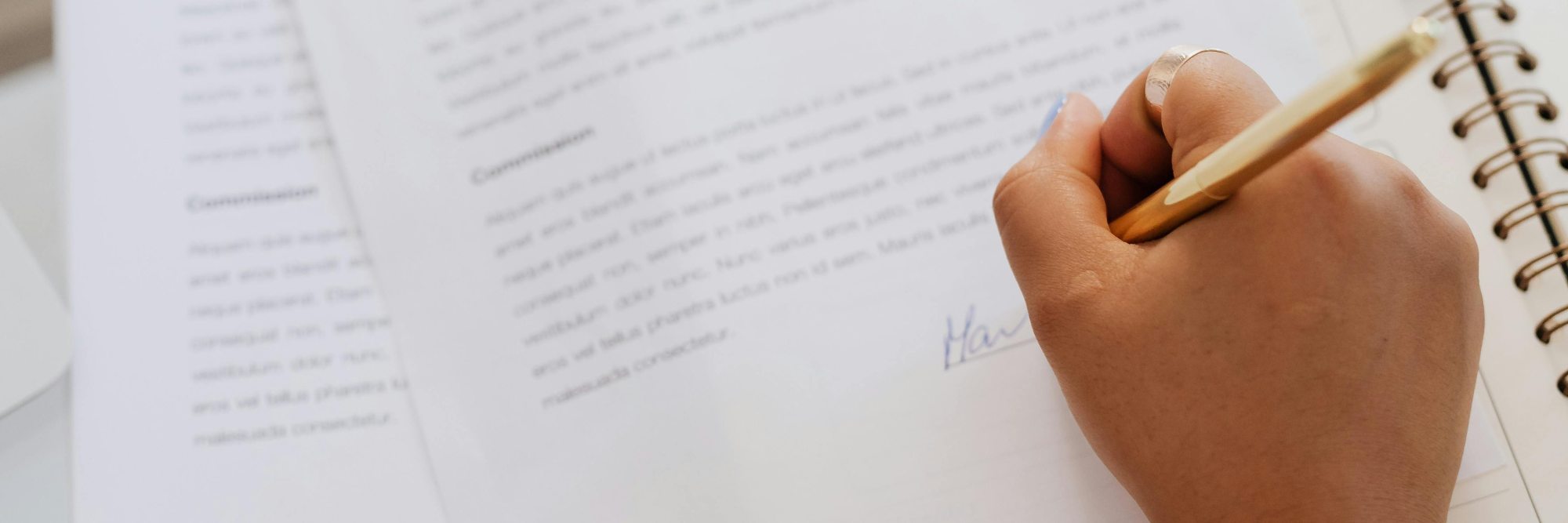 main signant un document avec un stylo
